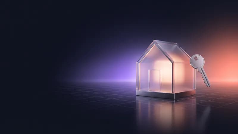 Casa de vidro iluminada por dentro, com uma chave de metal ao lado.